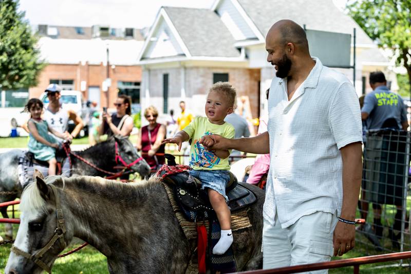 Plainfield resident Ocean Gaines, with a little help from Emerald Gaines, enjoys a pony ride during Plainfield Fest on June 29, 2025.