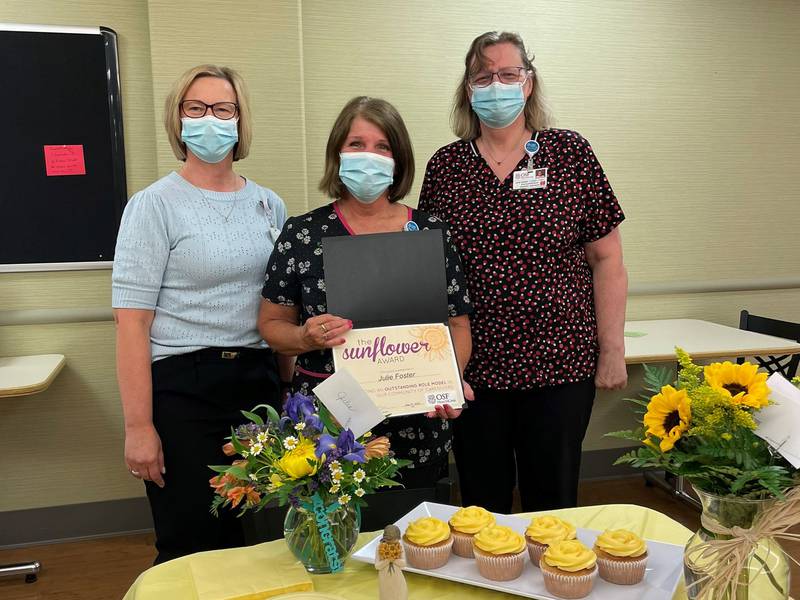 Congratulating Julie Foster (middle), the 2022 Sunflower Award winner are (left to right) Jackie Kernan, president, and Julia Geiger, Environmental Services supervisor.