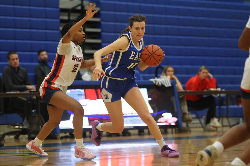 Lincoln-Way East’s Maddie Yacobozzi drives around Romeoville’s Jaylen Zachary in the Sandburg Holiday Classic semifinal on Thursday, Dec. 28th, 2023 in Orland Park.