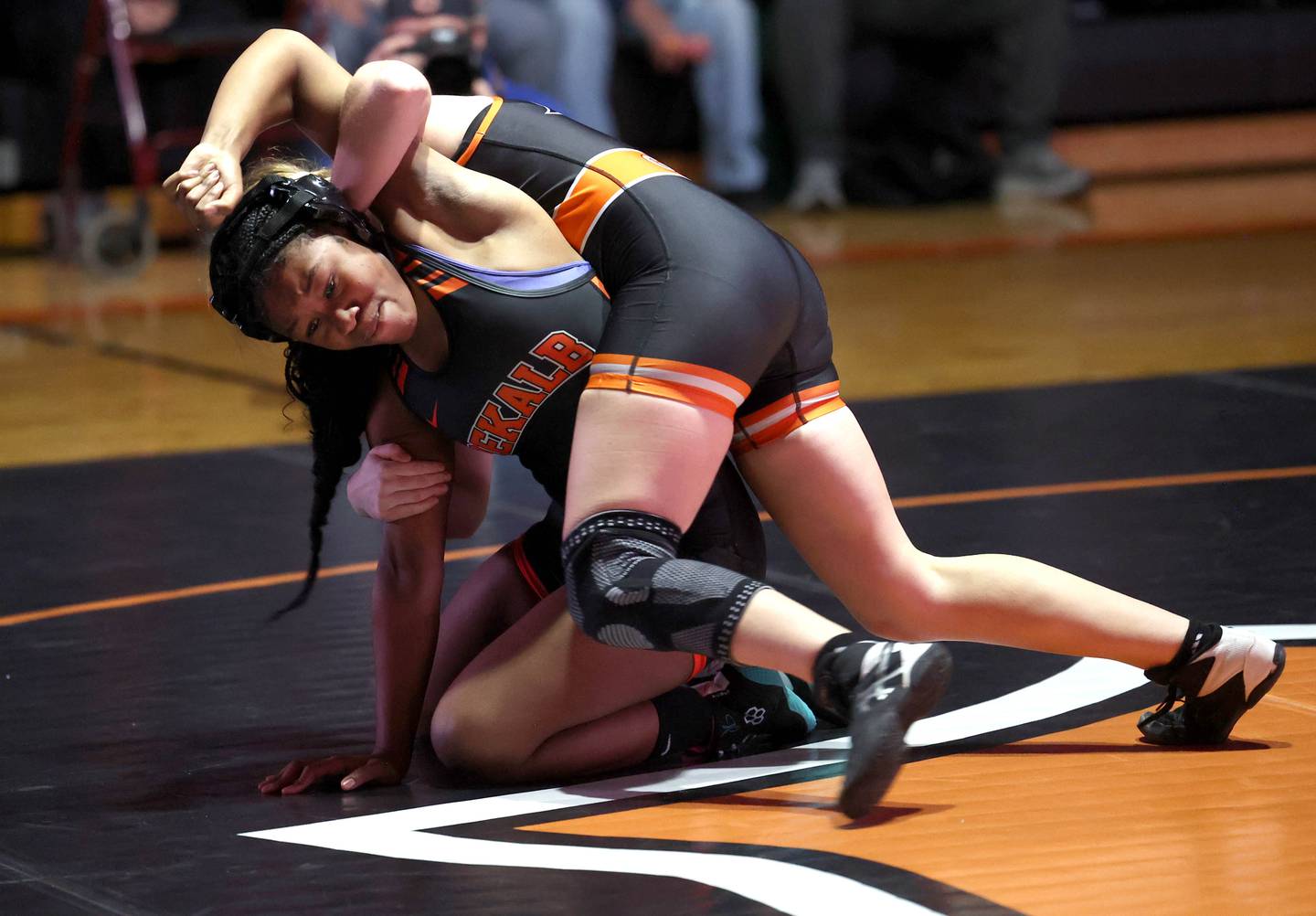 Kaneland’s Bella Gruber (top)  turns DeKalb’s Kayden Johnson during their 130 pound match Wednesday, Jan. 7, 2026, at DeKalb High School.