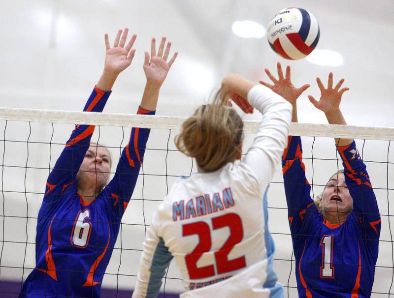 Genoa-Kingston’s Addison Vicary, left, and Presley Meyer, right, block against Marian Central’s Hadley Rogge in varsity volleyball tournament action on Saturday, Sept. 21, 2024, at Hampshire High School in Hampshire.