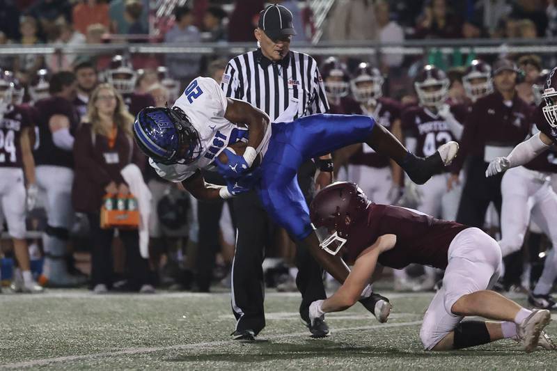 Lincoln-Way East’s Zion Gist leaps a tackle for extra yards on a run against Lockport on Friday, Sept. 29, 2023 in Lockport.