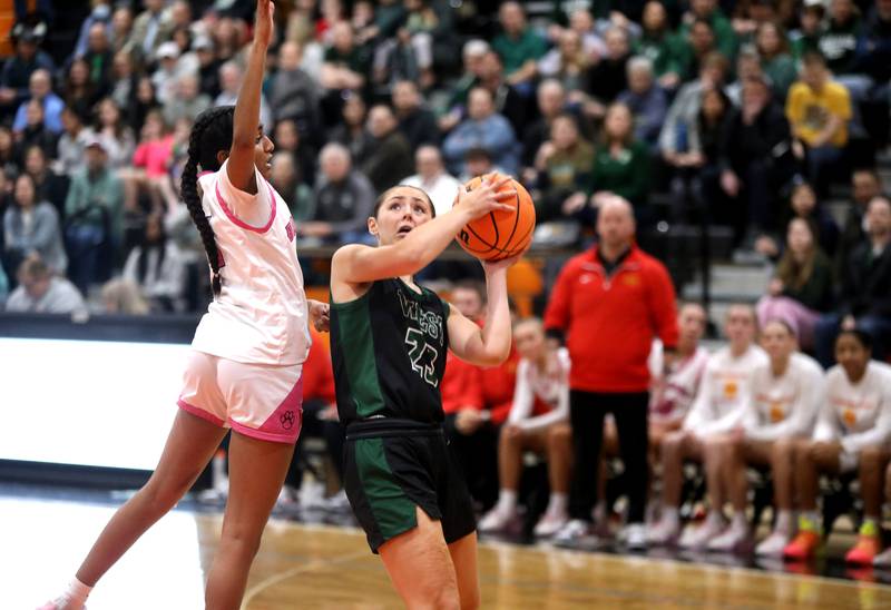 Glenbard West's Mya Austin attempts a shot past Batavia's Julia Arulandu during the Class 4A St. Charles East Sectional final on Thursday, Feb. 27, 2025 in St. Charles.