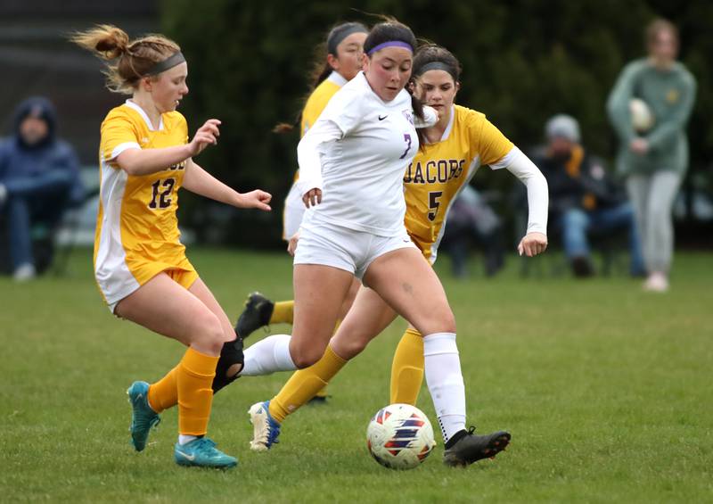 Hampshire’s Ilse Marquez, center, moves through Jacobs’ Clare Leib, left, and Brenna Flaskamp, right, in varsity girls soccer on Thursday, April 17, 2025, at Jacobs High School in Algonquin.