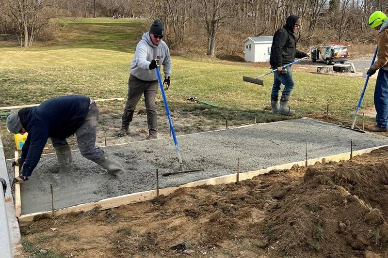 (Left to right); Andrew Young, Phil Schueler, Matt Young, and Greg Ottens help Pro-Tec Services Concrete and Excavating pour cement for new benches and a water fountain walk path at the Morrison Bark Park Friday, Dec. 2. The pet-friendly water fountain, donated by Elkay Manufacturing Co, and donor signage will be installed next spring.