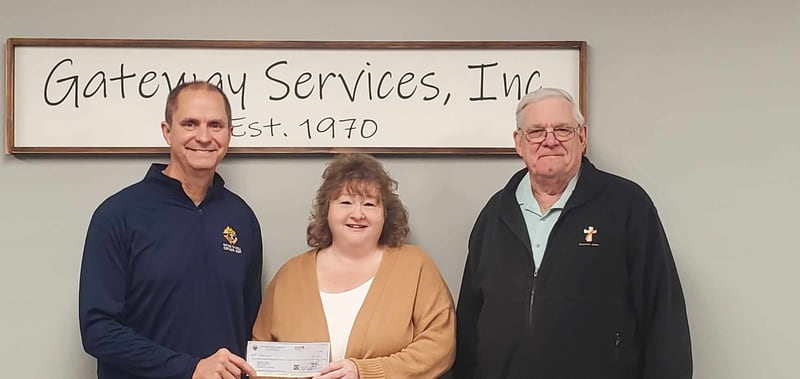 Tim Smith, grand knight of the Father Edward Farrell Knights of Columbus 5591 in Princeton (left) and Tootsie Roll Drive Chairperson Deacon John Murphy (right) present a check for $3,000 to Tracy Wright, CEO of Gateway Services.