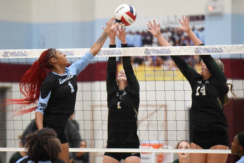 Kankakee's Ki'Asia Wilson, left, looks to place a hit over Bishop McNamara's Montana Reid, center, and Kate Dole during an All-City game at Kankakee Wednesday, Sept. 3, 2025.