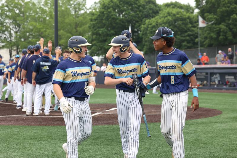 Ottawa Marquette’s Grady Dose, center, and Connor Baker, right, praise teammate Grant Dose following the Crusaders' 16-1 victory over Lexington in the IHSA Class 1A State semifinal on Friday, June 6, 2025.