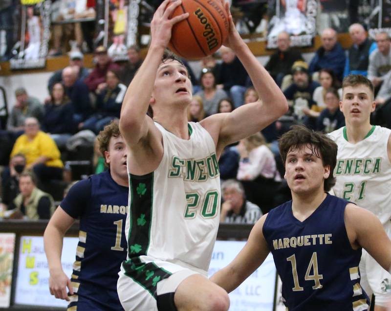 Seneca's Calvin Maierhofer drives to the basket around Marquette's Krew Bond and Alex Graham during the Tri-County Conference championship game on Friday, Jan. 27, 2023 at Putnam County High School.