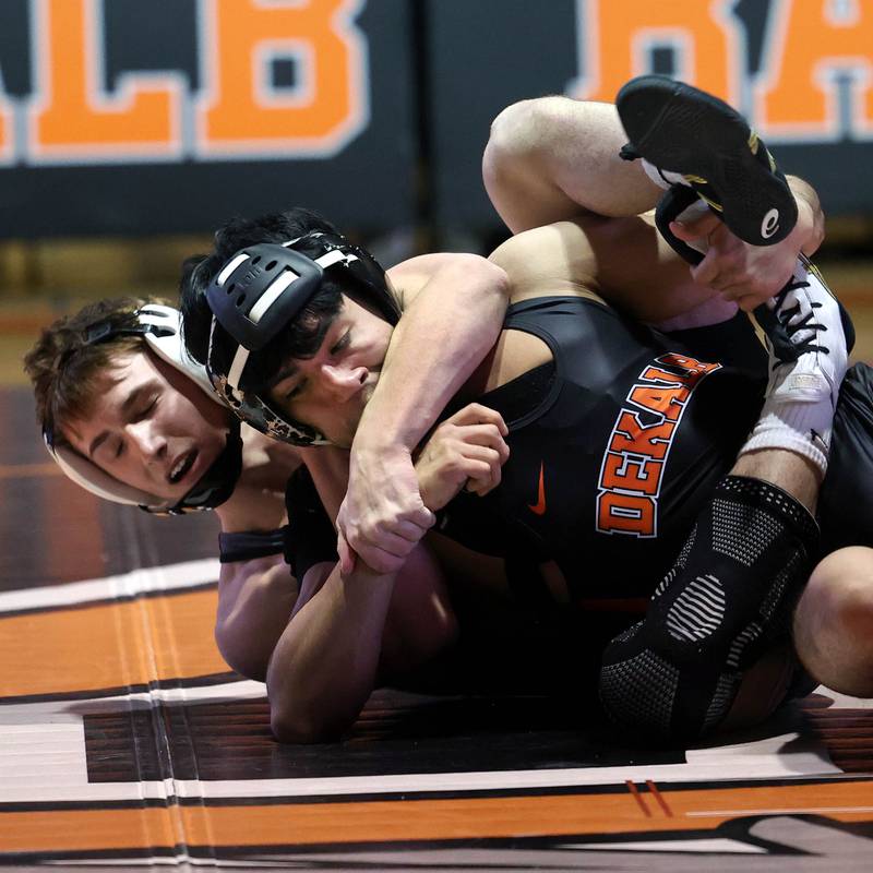 Sycamore’s Jayden Dohogne brings down DeKalb’s Alan Izaguirre Friday, Jan. 17, 2025, during their 138 pound match at DeKalb High School.