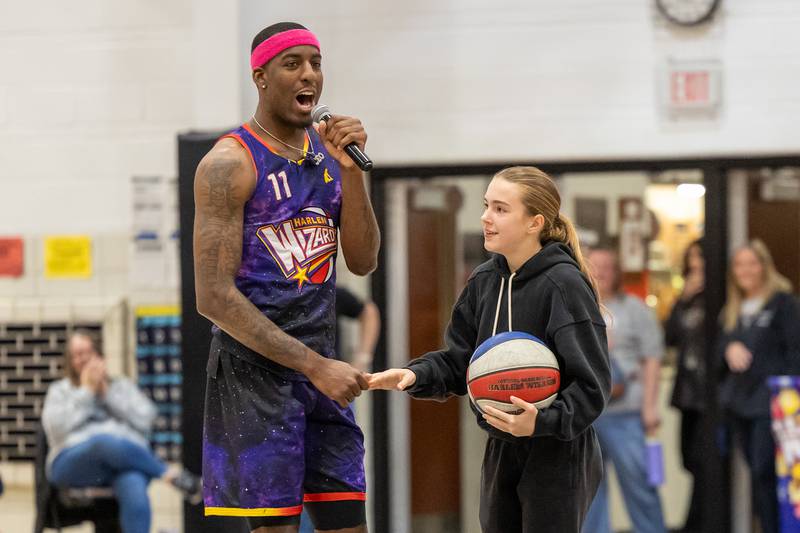 Kamil “Dragon” Brown (77) of the Harlem Wizards shakes hand of child on Wednesday, April 16, 2025 at Woodland High School in Streator.