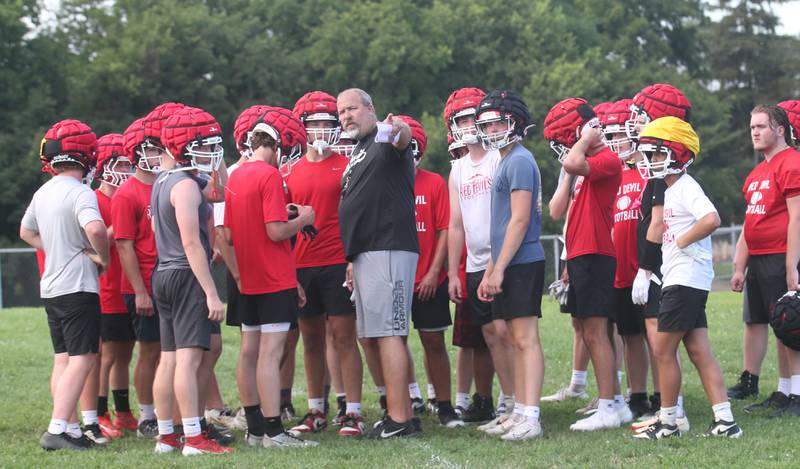 Hall football head coach Nick Sterling, huddles with his team during the first day of football practice on Monday, Aug. 11, 2025 at Hall High School.