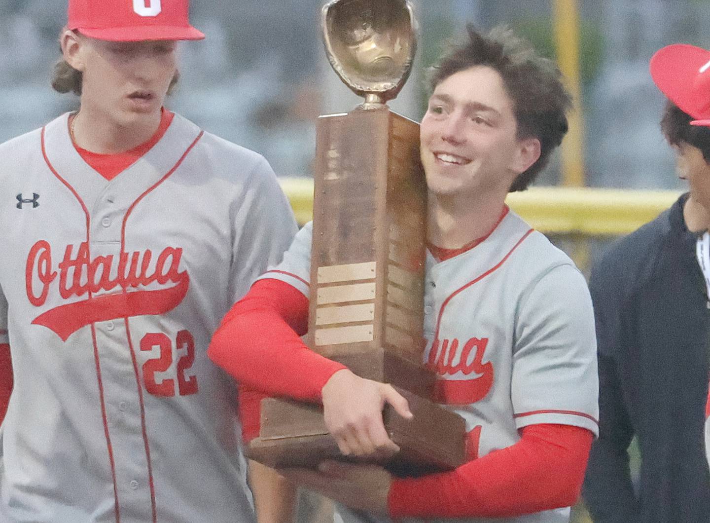 Ottawa's Adam Swanson hugs the Illinois River Rivalry trophy after defeating L-P on Thursday, April 30, 2026 at Huby Sarver Field in the L-P Athletic Complex in La Salle.
