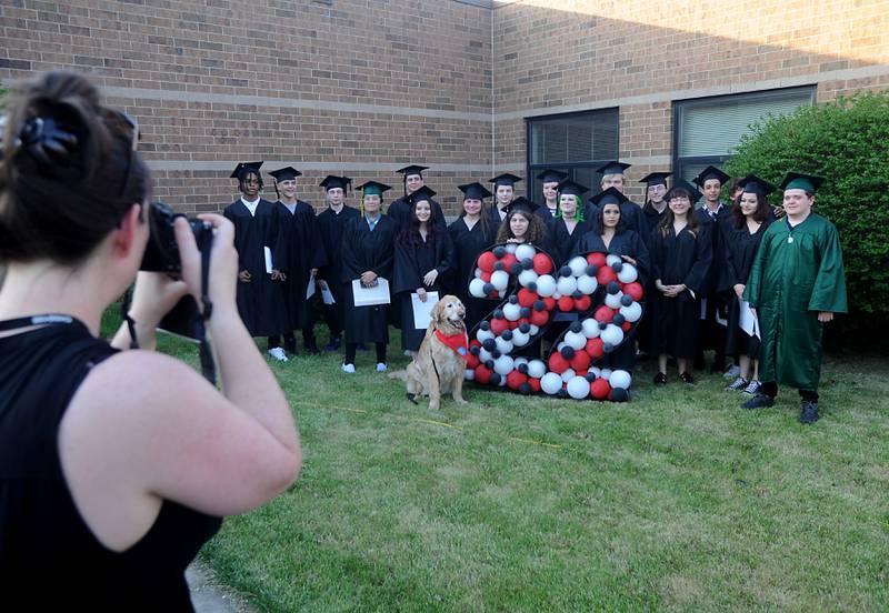The Haber Oaks Campus graduating class of 2022 poses for a class photo with Henry, a therapy dog that comes to the school with teacher, Anne Whitney-Turbidy, on Thursday, May 12, 2022, during the school's graduation celebration in the courtyard of Crystal Lake South High School.