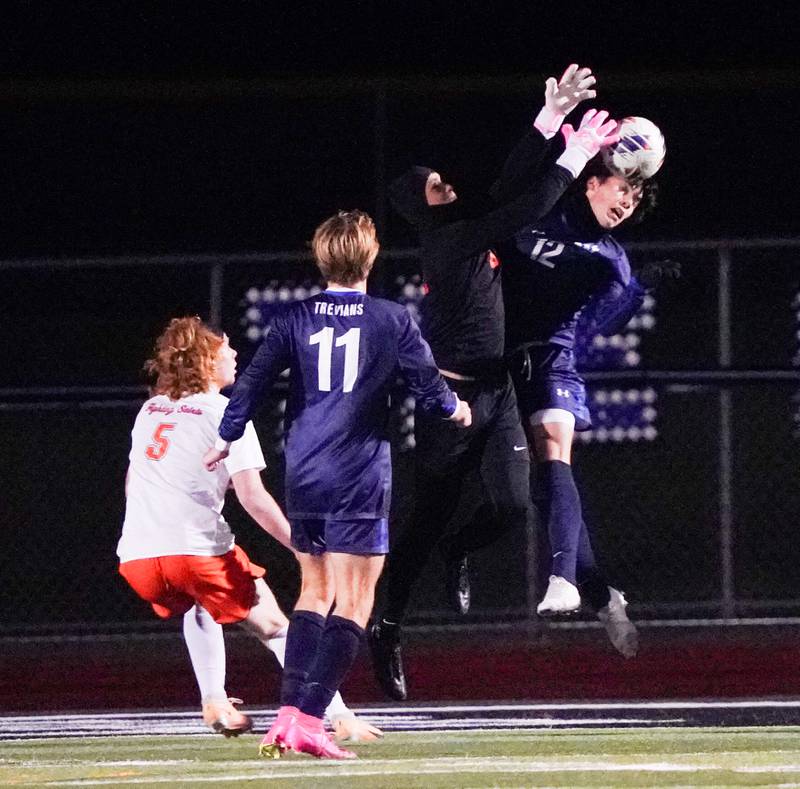 St. Charles East's Jordan Rolon (85) collides with New Trier's Francis Fernandez (12) while defending the net during the class 3A St. Charles North Boys Soccer Supersectional match at St. Charles North High School on Wednesday, Nov. 1, 2023.