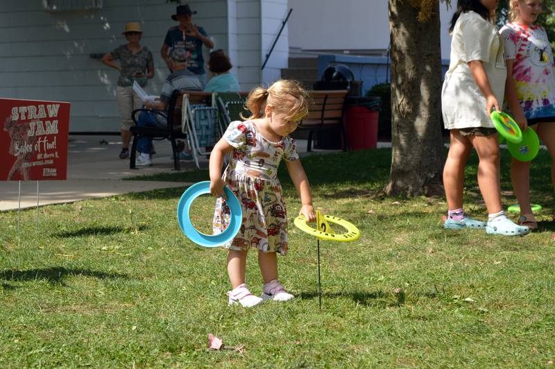 Meredith Murphy, 2, of Rochelle, plays with disc golf discs on Saturday, Aug. 24, 2024, on the Mt. Morris College Campus during StrawFest, a part of the ninth annual U.S. National Straw Sculpting Competition.
