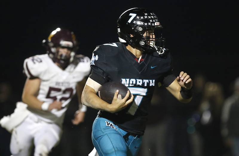Woodstock North's Parker Halihan runs with the ball as Richmond-Burton's Bryce Kowall give chase during a Kishwaukee River Conference football game on Friday, Oct. 10, 2025, at Woodstock North High School.