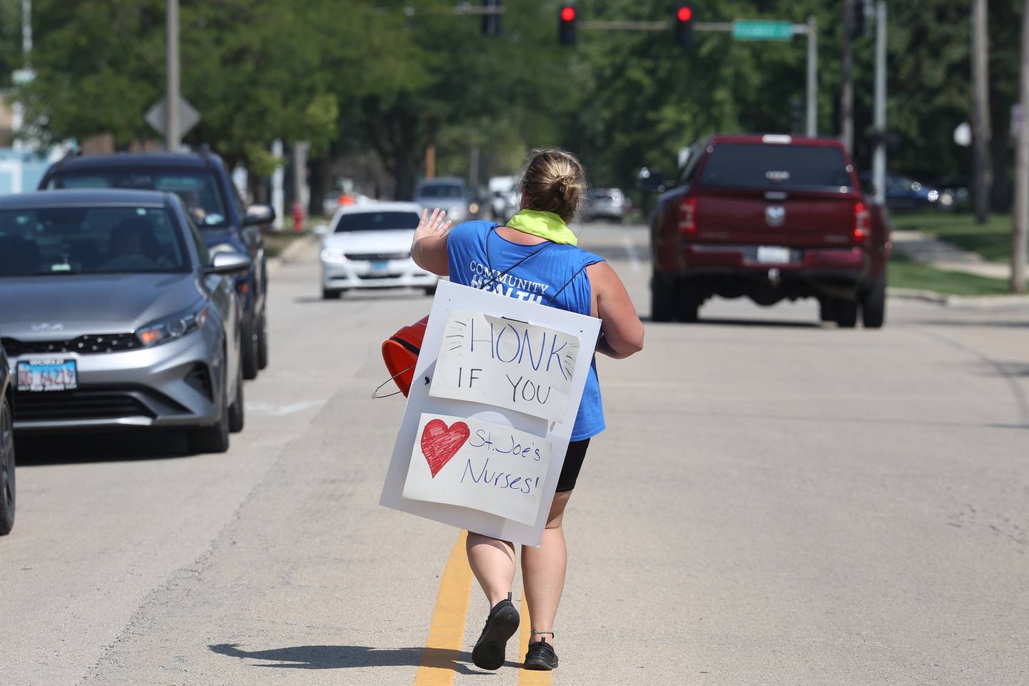 Jenn Onderisin, an IC nurse at St. Joe’s, wave to cars as they honk in support of the nurses strike outside Ascension Saint Joseph-Joliet hospital on Thursday, Aug. 24, 2023.