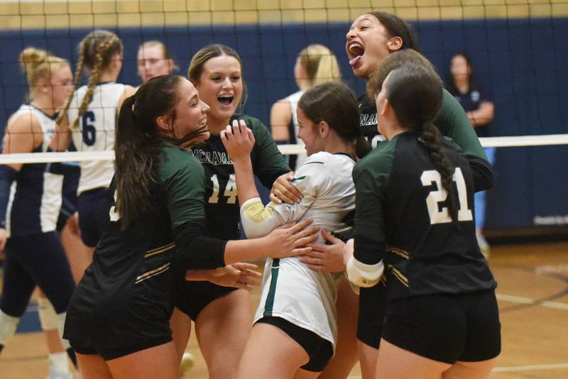 Members of the Bishop McNamara girls volleyball team congratulate Gianna Brosseau, center, on her diving dig that landed over the net for a point during the Fightin' Irish's game at Cissna Park Wednesday, Oct. 15, 2025.