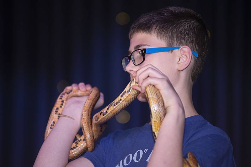 Jacob Czyzyk shows off why Great-balls-of-fire is called a corn snake. The slithery guy was one of two corn snakes brought in by Hoo Haven to the April 14, 2022 program. The pattern on their bellies resemble Indian corn.