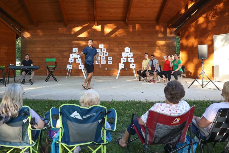 GreenRoom Improv cast wait as David Hunter, center, sets the stage for their show hosted by the Morris Library at Goold Park on Friday, Aug. 11, 2023 in Morris.