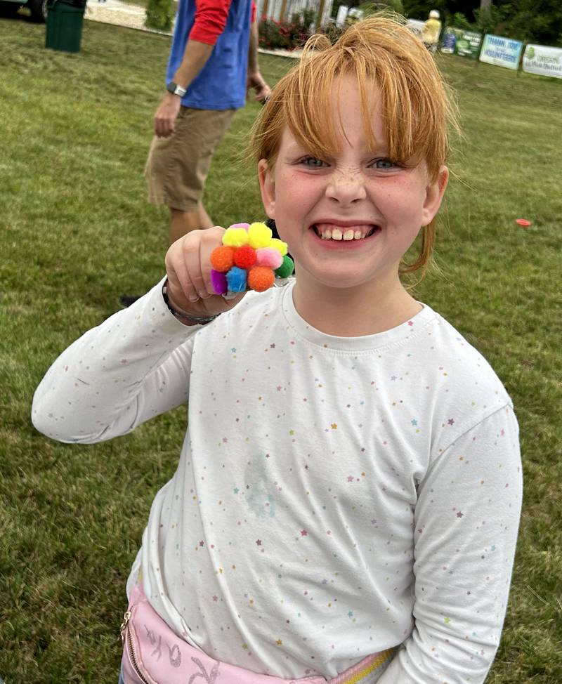 Raya Windham, 8, of Oregon, shows the jellyfish she made at one of the craft tables at National Night Out, hosted by the Oregon Police Department and Oregon Park District at River's Edge Experience in Oregon on Tuesday, Aug. 6, 2024.
