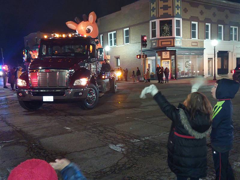 Children get excited about the floats passing by Saturday, Dec. 2, 2023, during the Lighted Christmas Parade in Peru.