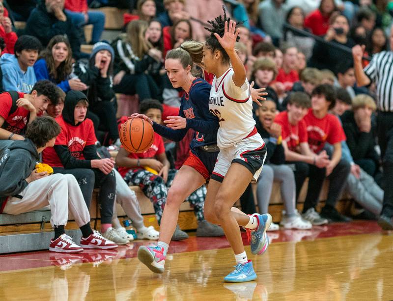Oswego’s Emily Mengerink (12) dribbles the ball while being defended by Yorkville's Alexandra Stewart (22) during the 13th annual Hoops 4 Hope Communities vs. Cancer basketball event at Yorkville High School on Saturday, Jan 28, 2023.
