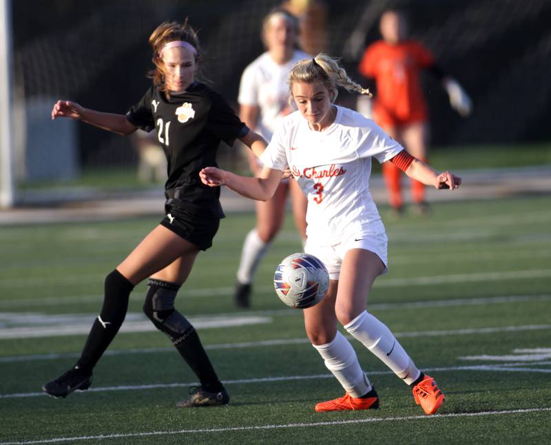 St. Charles East’s Lauren Silvestri (right) gets control of the ball away from Wheaton Warrenville South’s Ashlyn Adams (left) during a game at Wheaton Warrenville South on Tuesday, April 18, 2023.
