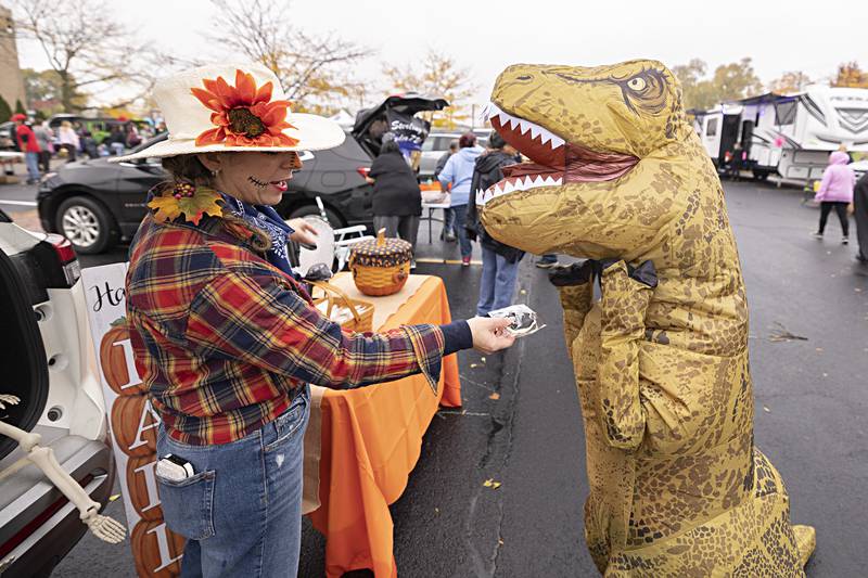 Claudia Garcia, owner/operator of Farm Girl Bakery, hands out cookies to Jurassic participants Wednesday, Oct. 25, 2023 at Sterling Police Department’s trunk-or-treat.
