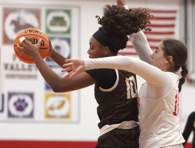 Jacobs’ Zara Lewis, left, handles the ball as Dundee-Crown’s Kate Graham defends in varsity girls basketball on Friday, Dec. 12, 2025, at Dundee-Crown High School in Carpentersville.