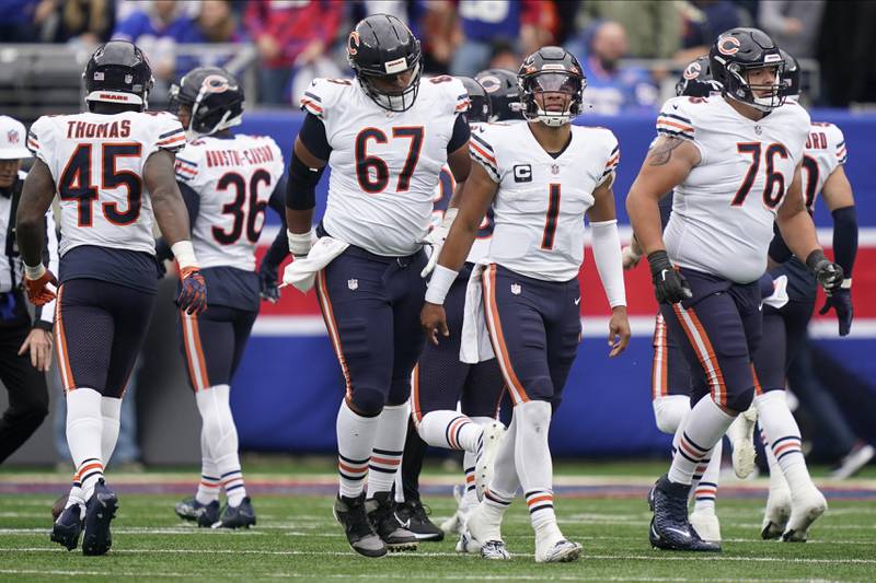 Chicago Bears quarterback Justin Fields (1), center Sam Mustipher (67) and offensive tackle Teven Jenkins (76) walk off the field near the end of the second quarter of an NFL football game against the New York Giants, Sunday, Oct. 2, 2022, in East Rutherford, N.J. (AP Photo/John Minchillo)