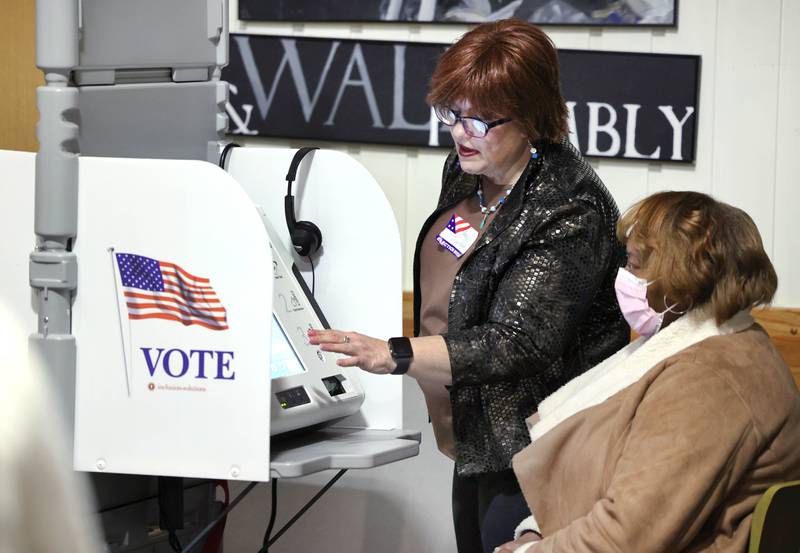 Election Judge Tamara Person-Hescott shows Patricia Doss, of DeKalb, how to use one of the new touch screen voting machines on Election Day, Tuesday, Nov. 8, 2022, at the polling place in Westminster Presbyterian Church in DeKalb.