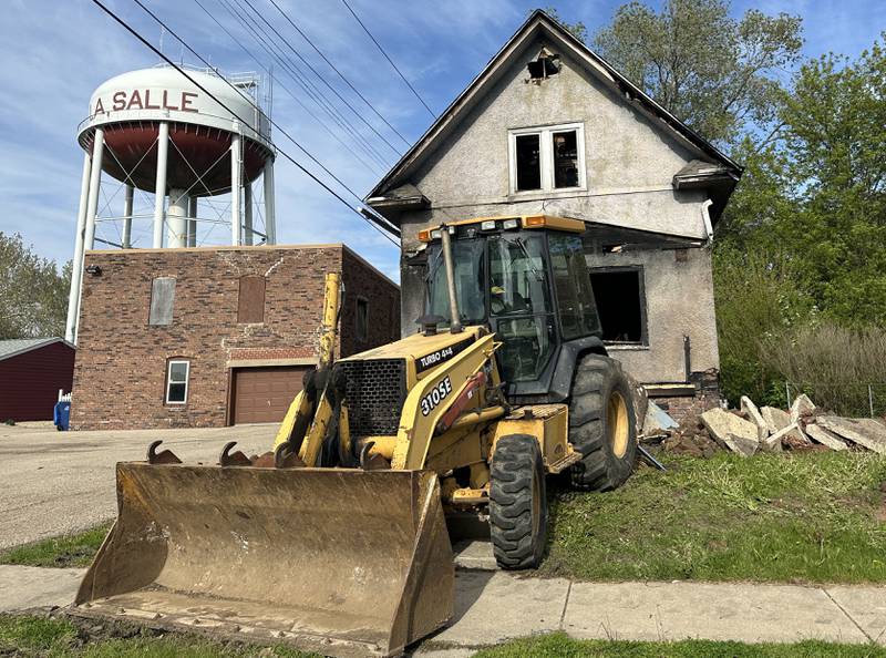 A backhoe begins to demolish a home located in the 800 block of Bucklin Street on Thursday, May 7, 2026 in La Salle. The home was destroyed by a fire on Jan. 23. Firefighters worked together to battle the blaze in subzero temperatures.