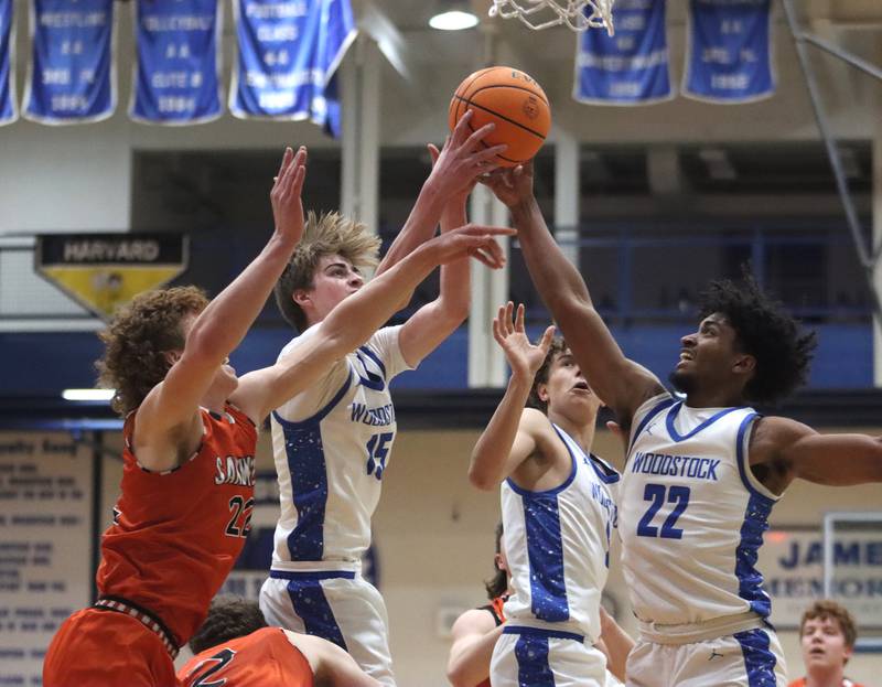 Sandwich’s Dom Rome, left, battles Woodstock’s Liam Laidig, Max Beard, and Tony Grzetic in varsity boys basketball on Tuesday, Feb. 11, 2025, at  Woodstock High School in Woodstock.