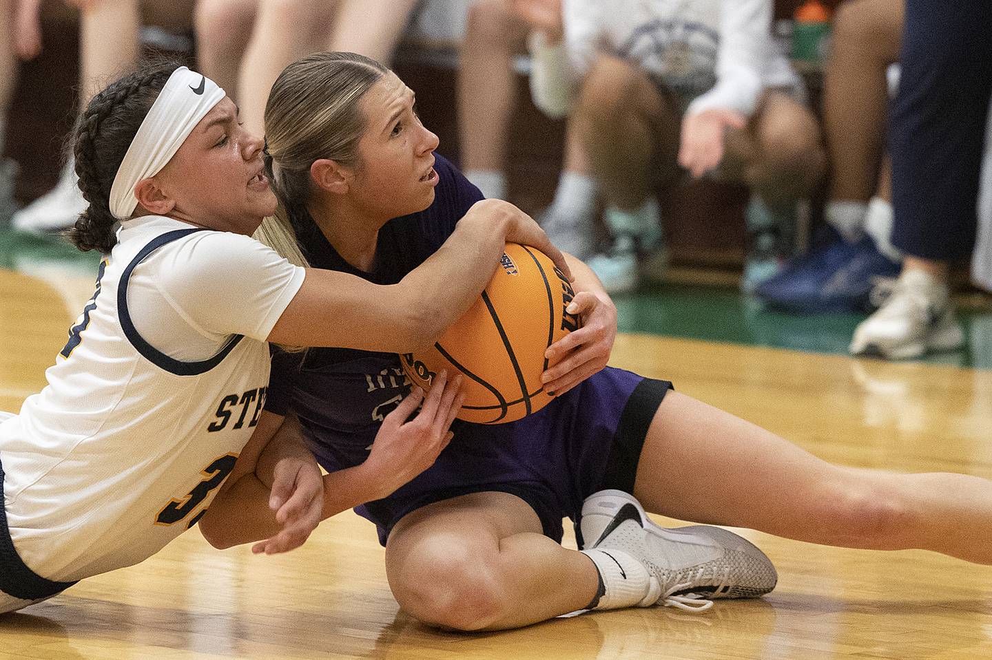 Sterling’s Joslynn James and Dixon's Morgan Hargrove fight for the ball Thursday, Feb. 27, 2025, during the Class 3A girls Sectional title at Rockford Boylan High School.