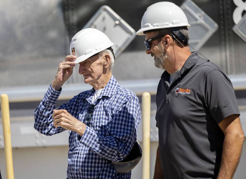 Bob Bonnell, father of owner Bonnell Industries owner Joe Bonnell (right) slips on a hard hat for the official groundbreaking Wednesday, August 30, 2023 of a new facility in Dixon.