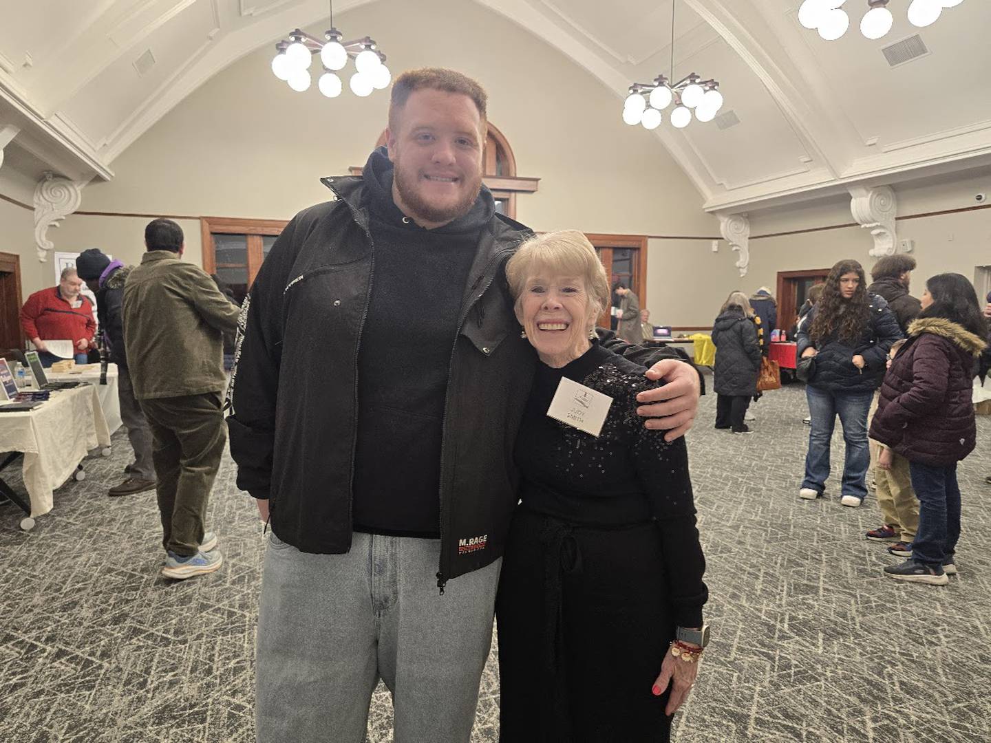 Dominic Pelayo of Crest Hill poses for a photo with his grandmother Judy Smith of Joliet during WriteOn Joliet's 9th Annual Anthology Release Party on Thursday, Dec. 4, 2025, at the Joliet Public Library. Pelayo recently graduated from Lewis University in Romeoville and is currently living with his parents due to lack of housing that fits needs and budget.