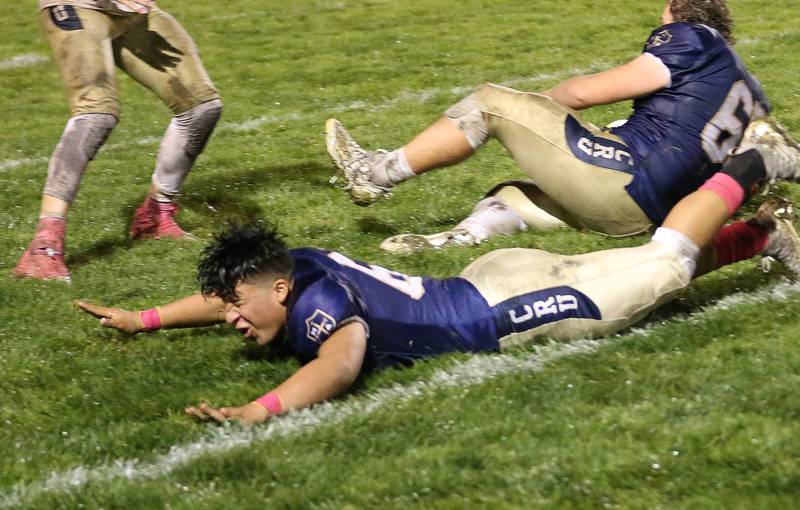 Marquette's Andrew Hamm dives on the wet turf after defeating St. Bede on Friday, Oct. 13, 2023 at Gould Stadium.