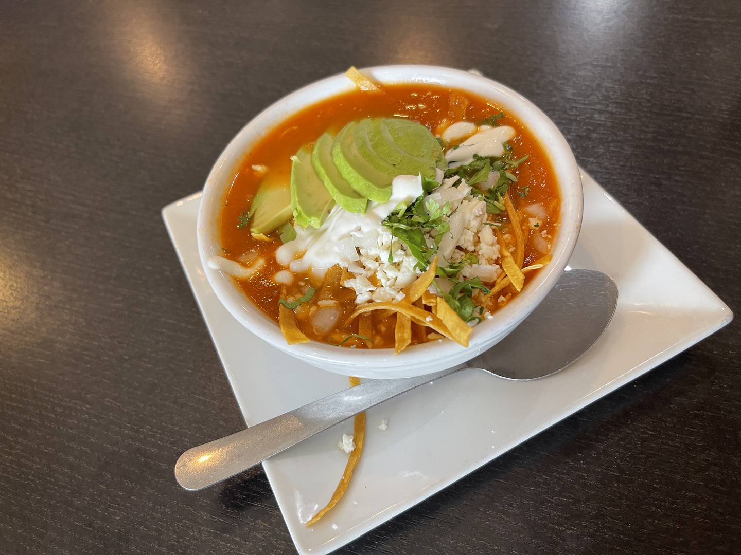 The small tortilla soup contained slices of avocado, tortilla strips, cheese, cilantro and all the normal fixings that come with the soup.