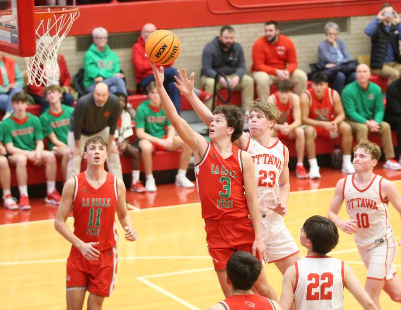 L-P's Mikey Hartman scores on a layup against Ottawa on Friday, Jan. 10, 2024 in Kingman Gym at Ottawa High School.