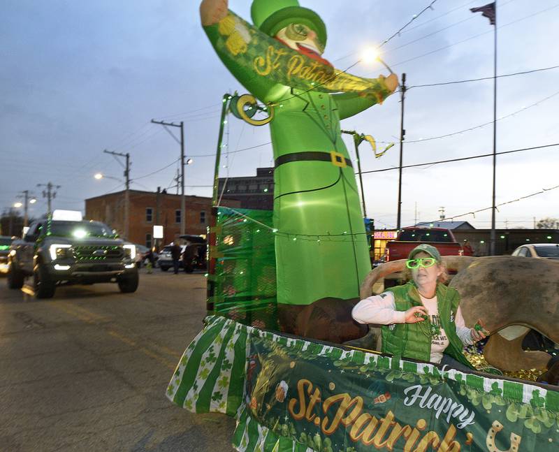 Those riding on the Lion’s Club float , toss candy treats to those along Main St. during the Marseilles Lighted St Patrick’s Day Parade Saturday.