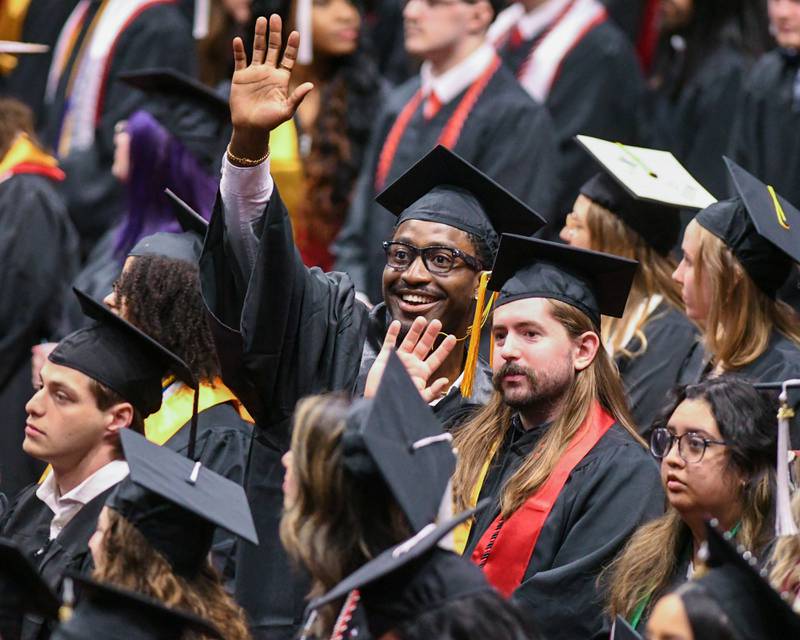 Northern Illinois University graduates wave to commencement goers on Saturday May 9, 2026, during the graduation ceremony held at the Convocation Center in DeKalb.