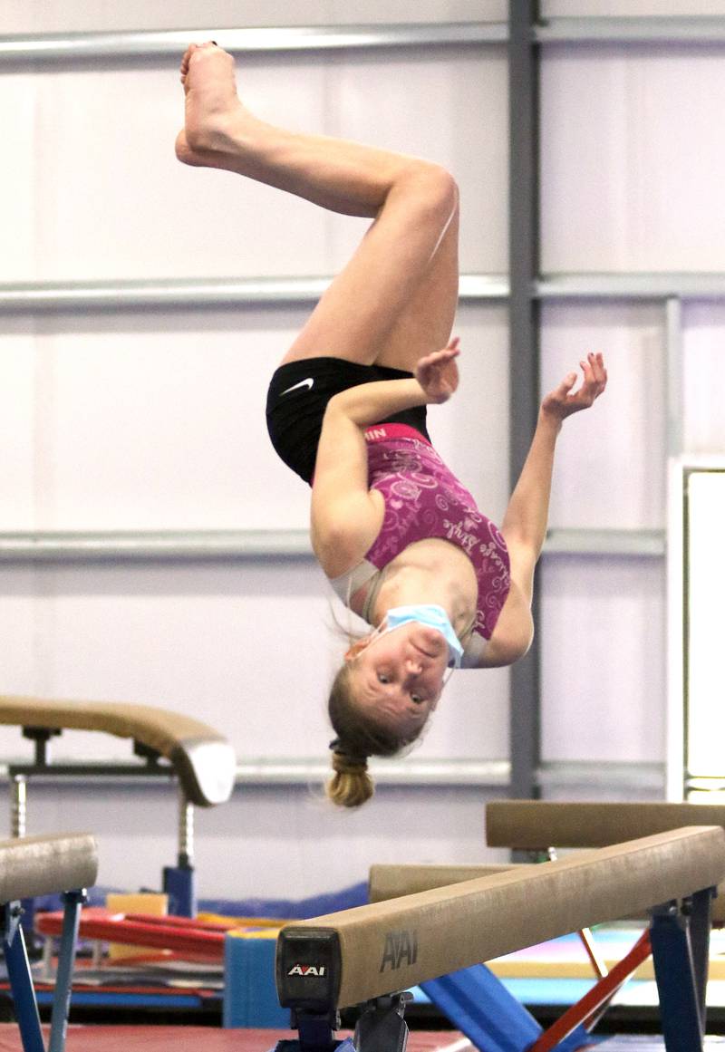 DeKalb-Sycamore co-op gymnastics sophomore Leah Benson works on her beam dismount Wednesday during practice at Energym in Sycamore.