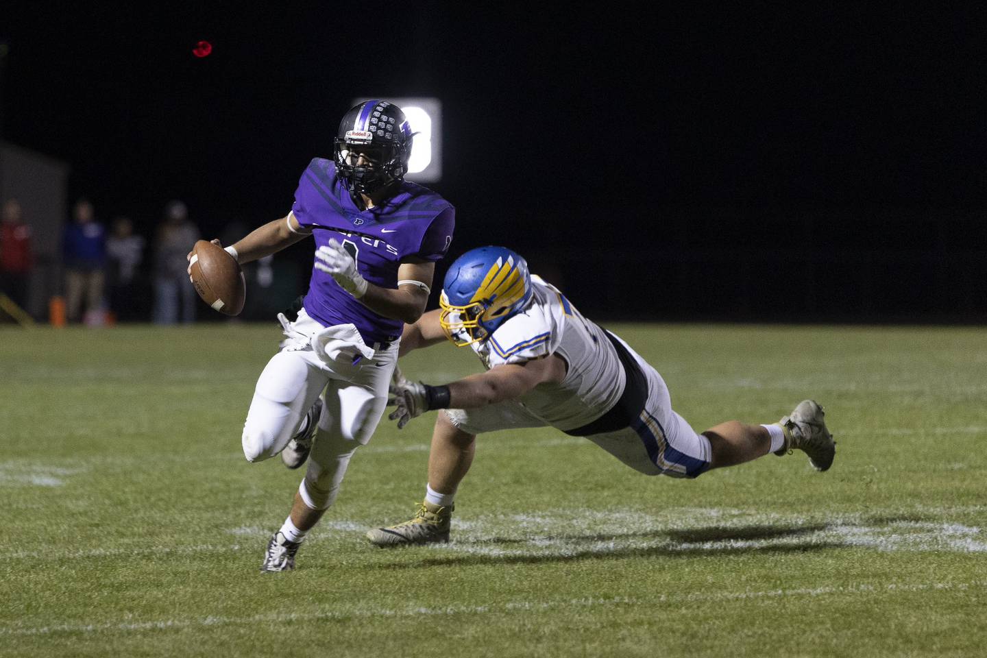 Plano quarterback Armando Martinez (1) eludes a Johnsburg defender during Friday's game in Plano.