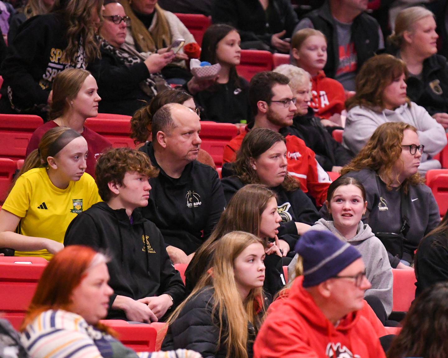 Sycamore's head coach Adam Bezinovich and assistant coach Meg Cohes watch former Sycamore players Northern Illinois University's Lexi Carlsen (20) and western Michigan University's Eveyn Carrier (23) play against each other on Saturday Jan. 11, 2025, held at the convocation Center in DeKalb.