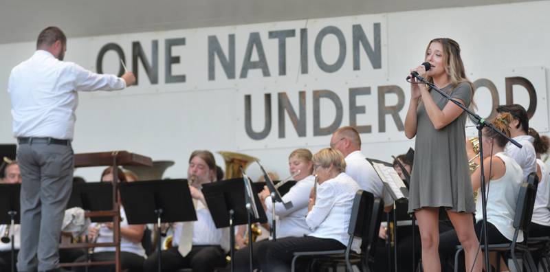 Bailee Fyock of Forreston sings a solo at the Kable Concert Band on Wednesday, July 23, 2025 in Mt. Morris as Travis Cunningham, conducts. Cunningham, the music/band teacher for Forreston High School and Junior High, was the guest conductor for evening concert. Fyock sang "For Good" from Wicked and "Let it Go" from Frozen.