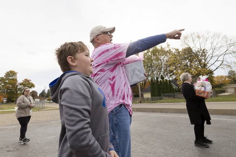 “That’s my little girl,” shouts dad Howard Craft with grandson Hunter Fisher, 10, Wednesday, Oct. 23, 2024, outside of Washington School. Peggy’s mom Marilyn Kollie and daughter Kyrie Fisher, 15, were also on hand for support.