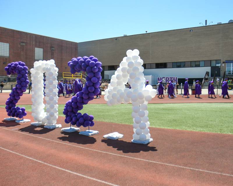 Downers Grove North graduates walk to the other side of Downers Grove North’s High School football field before making their way to their seats during graduation on Sunday May 19, 2024.