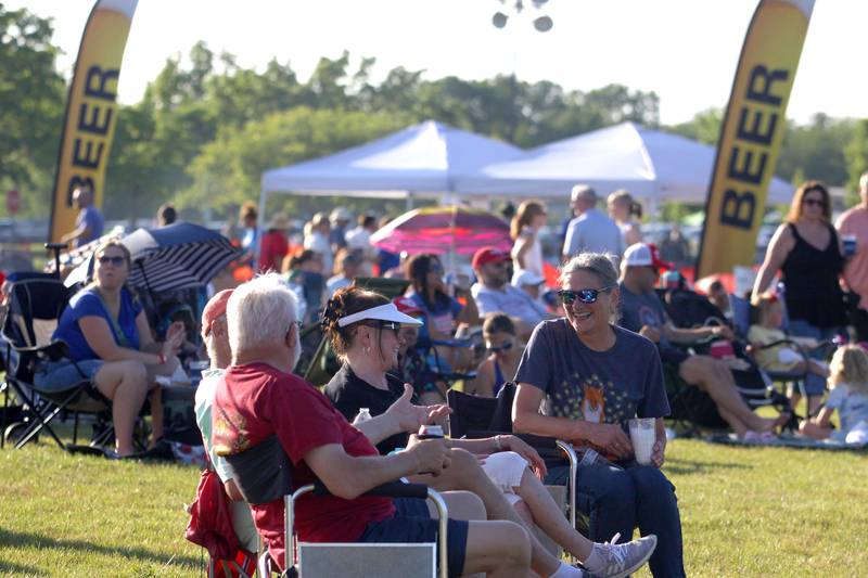 People visit as they wait for the Modern Day Romeos to take the stage during the Stars N’ Stripes Fest at Cary-Grove Park in Cary on Saturday, June 28, 2025.